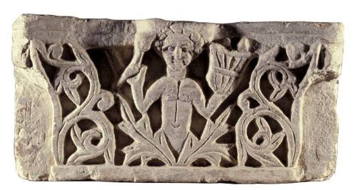 Architectural fragment with half-length figure emerging from foliage