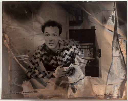 Jello Biafra at table with newspaper/chemical reaction on paper