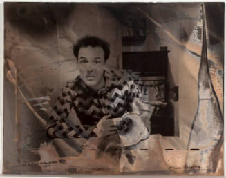 Jello Biafra at table with newspaper/chemical reaction on paper