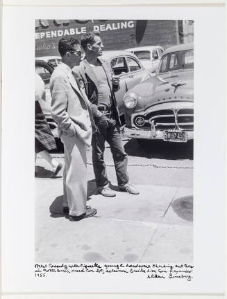 Neal Cassady at North Beach used car lot, San Francisco, standing with salesman