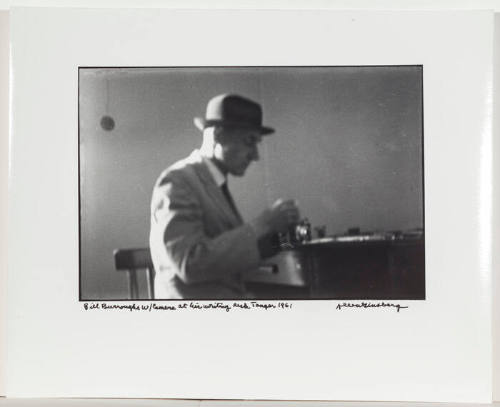 William Burroughs with camera, at his writing desk, Tangier