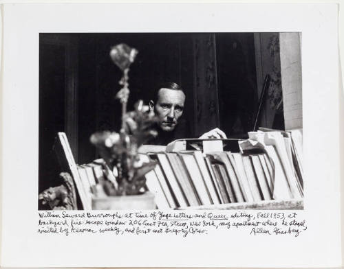 William Burroughs 206 E 7th Street, looking out the window with books in front